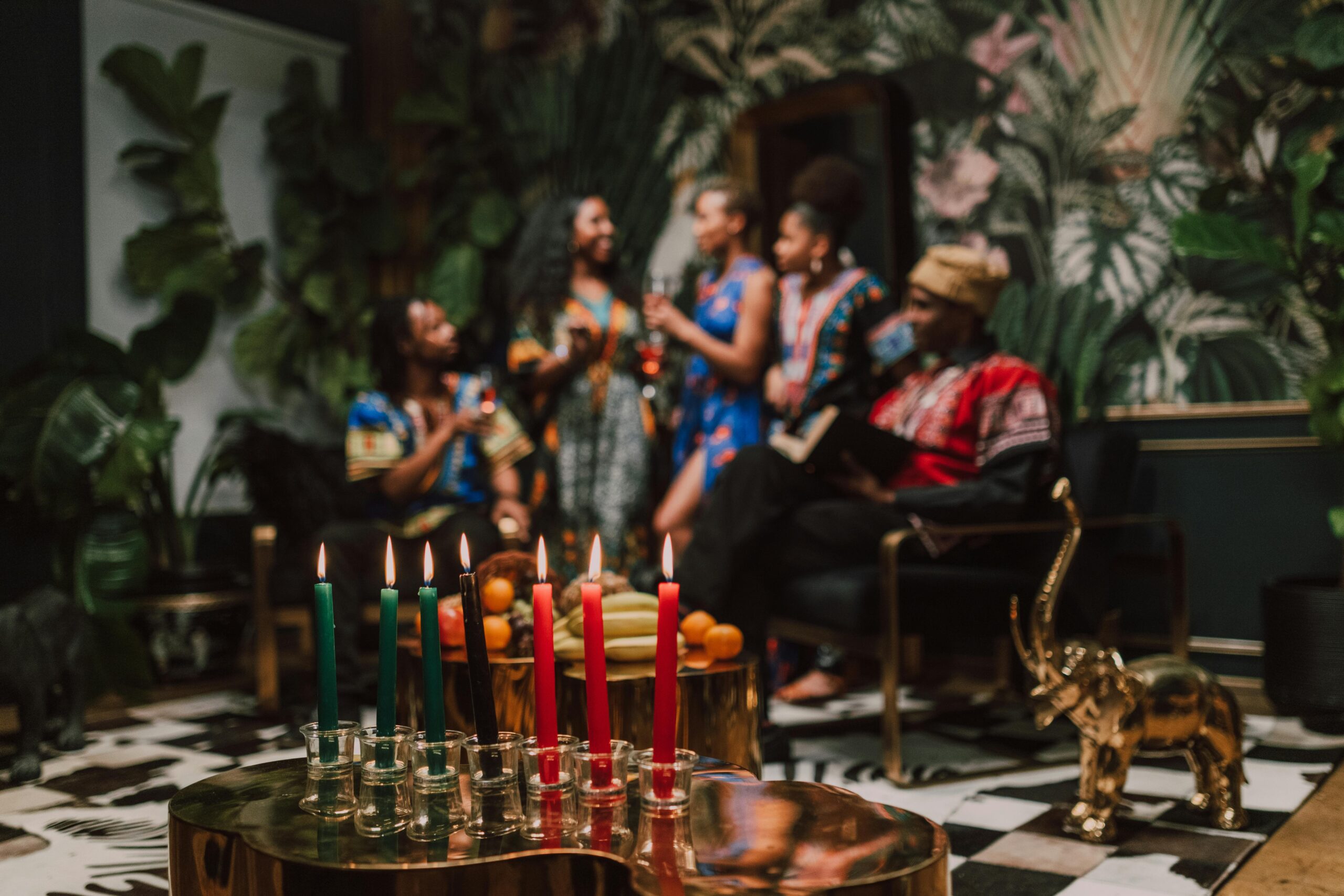 A vibrant Kwanzaa celebration featuring a Kinara with African traditional wear indoors.